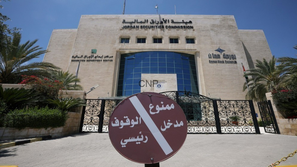 image - Center News Network Front view of the Jordan Securities Commission building with a large circular Arabic no-entry sign at the gate and palm trees on both sides.