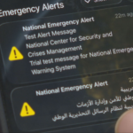 Smartphone screen showing two National Emergency Alerts with yellow warning icons and bilingual English/Arabic text.