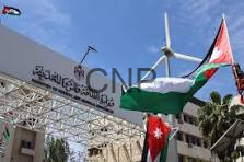 image - Center News Network Outdoor event stage with a metal truss, Arabic banner, and Jordan and Palestinian flags waving against a blue sky.