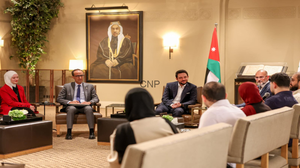 image - Center News Network Diplomatic meeting in a formal lounge with attendees seated in chairs around coffee tables and a Jordan flag in the background
