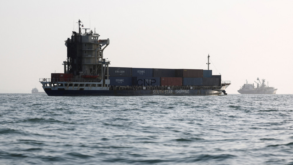 Container ship sailing on calm ocean with stacked colorful cargo containers on deck