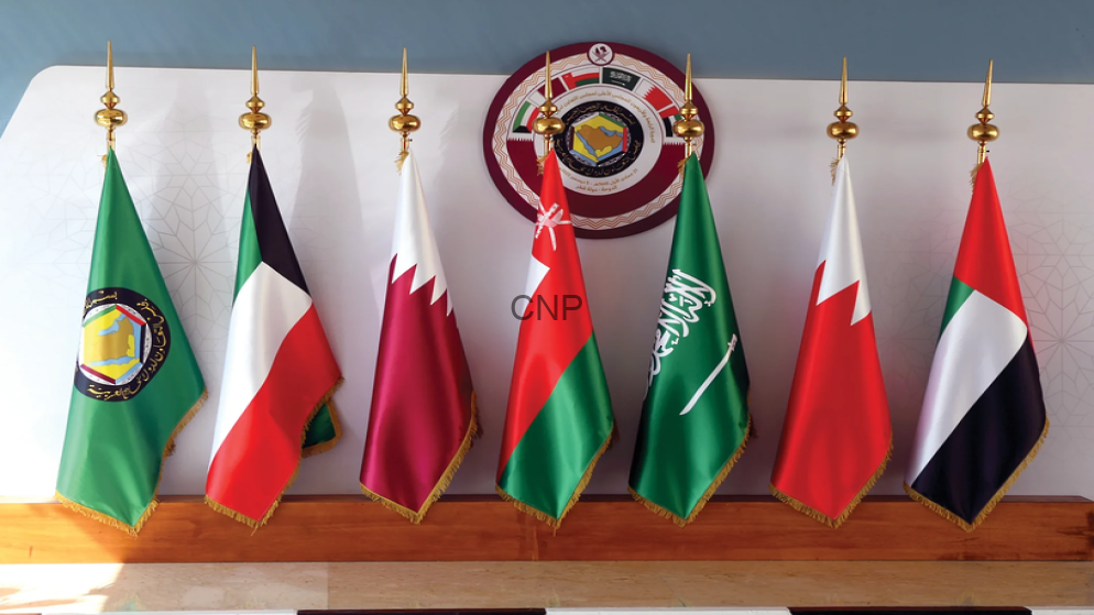 image - Center News Network Seven national flags on a wooden podium with gold finials, arranged in a row in front of a wall with a circular seal.