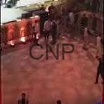 Nighttime street scene with a small crowd near red barricades; a 'CNP' watermark spans the center.