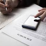 Hands rest on a desk with papers, a pen, and a smartphone nearby; a document shows the letters 'CNP' half-visible.