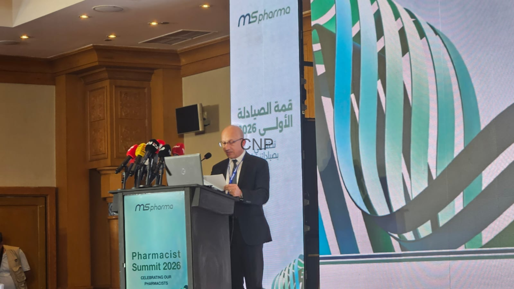 Speaker at a conference podium with multiple microphones during Pharmacist Summit 2026, MS Pharma branding on the screen behind him.